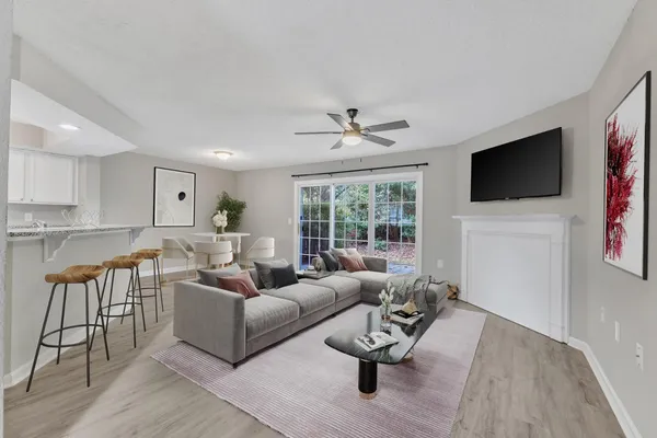 a living room with furniture a flat screen tv and a large window