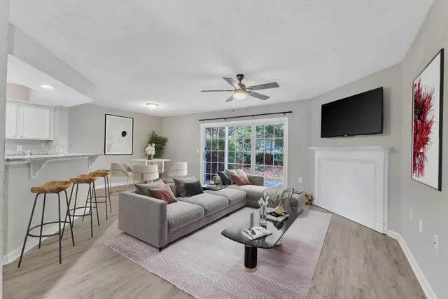 a living room with furniture a flat screen tv and a large window