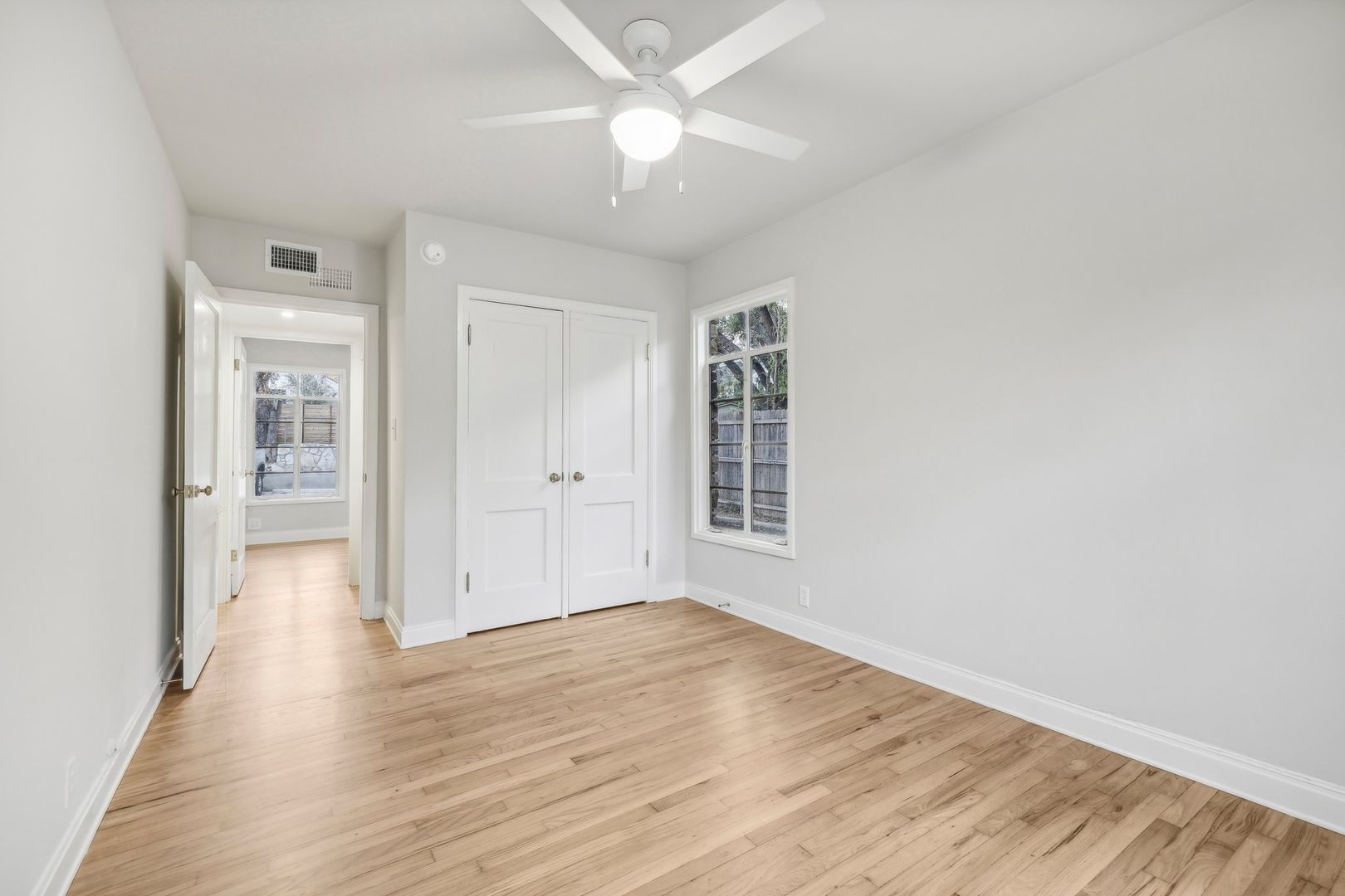 3010 Windsor Road, Unit E Austin, TX 78703 - Photo 13 of 21 an empty room with wooden floor and a ceiling fan