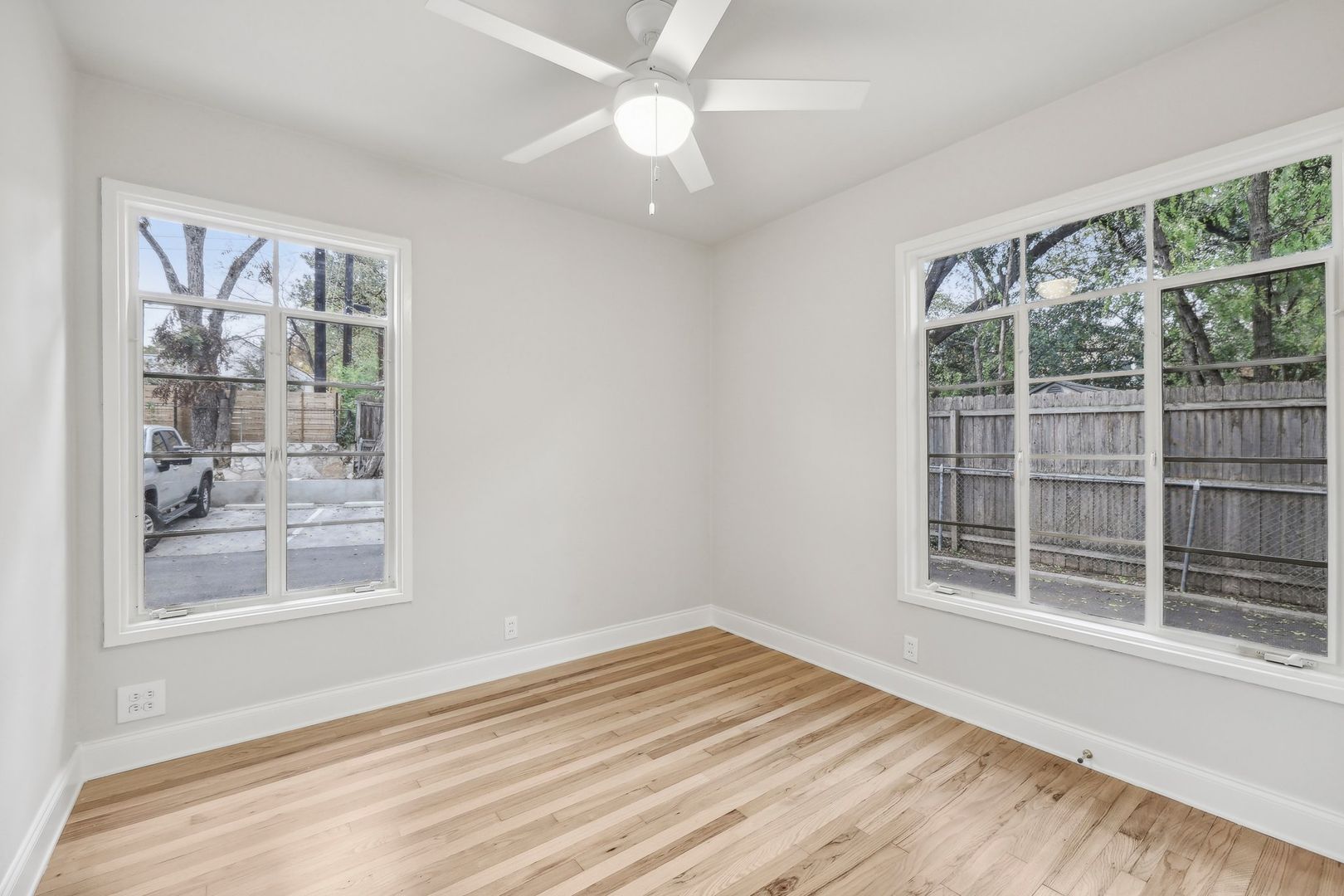 3010 Windsor Road, Unit E Austin, TX 78703 - Photo 15 of 21 a view of an empty room with a window and wooden floor