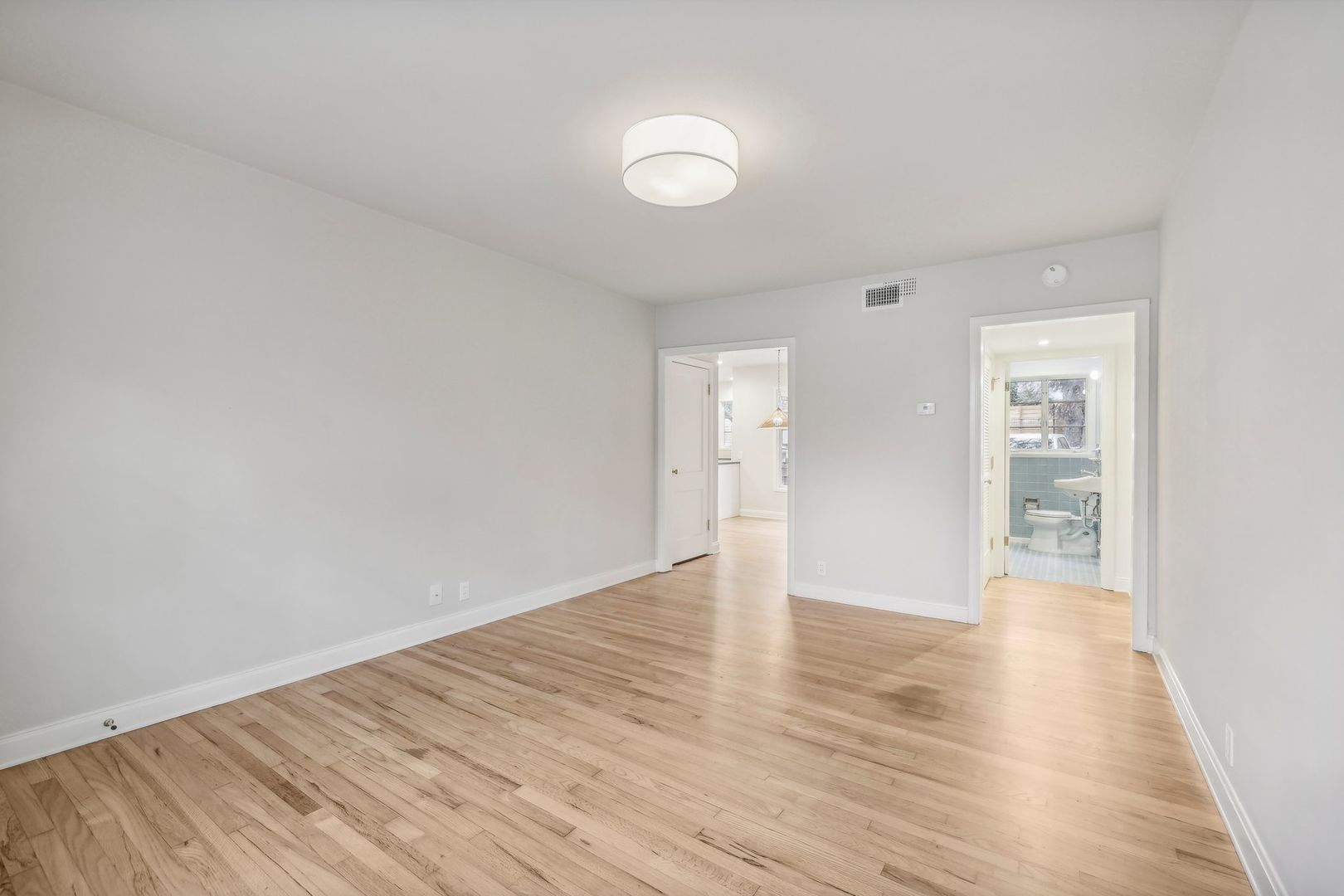 3010 Windsor Road, Unit E Austin, TX 78703 - Photo 5 of 21 a view of an empty room with wooden floor and a window