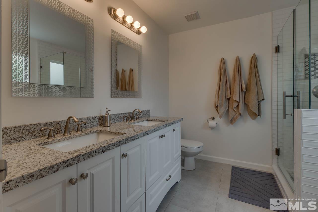 960 Twin Pines Road Reno, NV 89509 - Photo 21 of 26 a bathroom with a granite countertop sink a toilet and a mirror