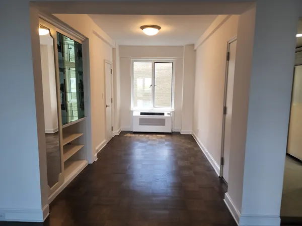 wooden floor in an empty room with a window