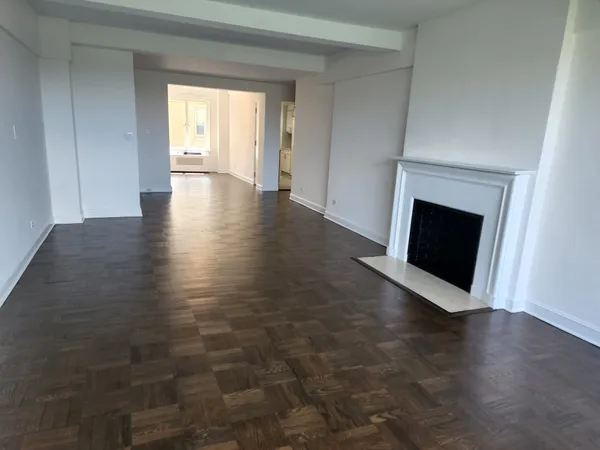an empty room with windows and fireplace