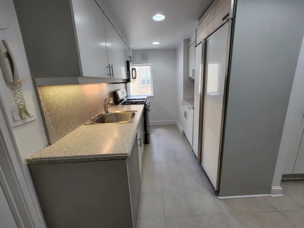 a kitchen with refrigerator and chairs