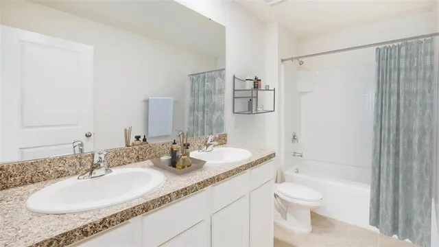 a bathroom with a granite countertop sink a toilet and shower