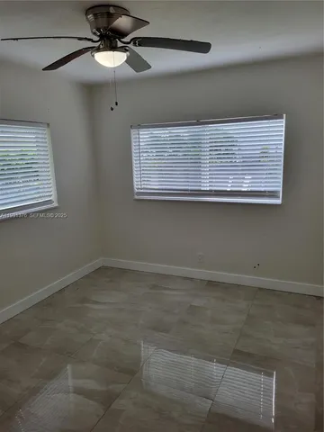 a view of a room with a ceiling fan and window