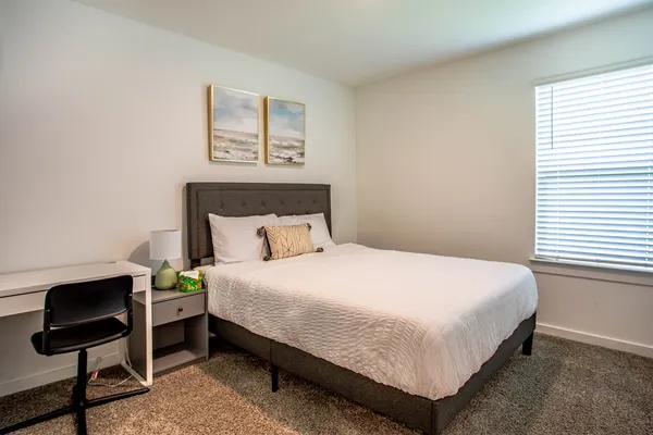 a bedroom with a bed a couch and a window