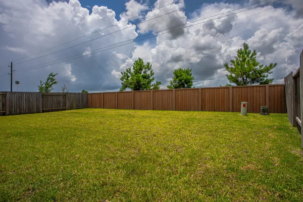 a view of yard with swimming pool and wooden fence