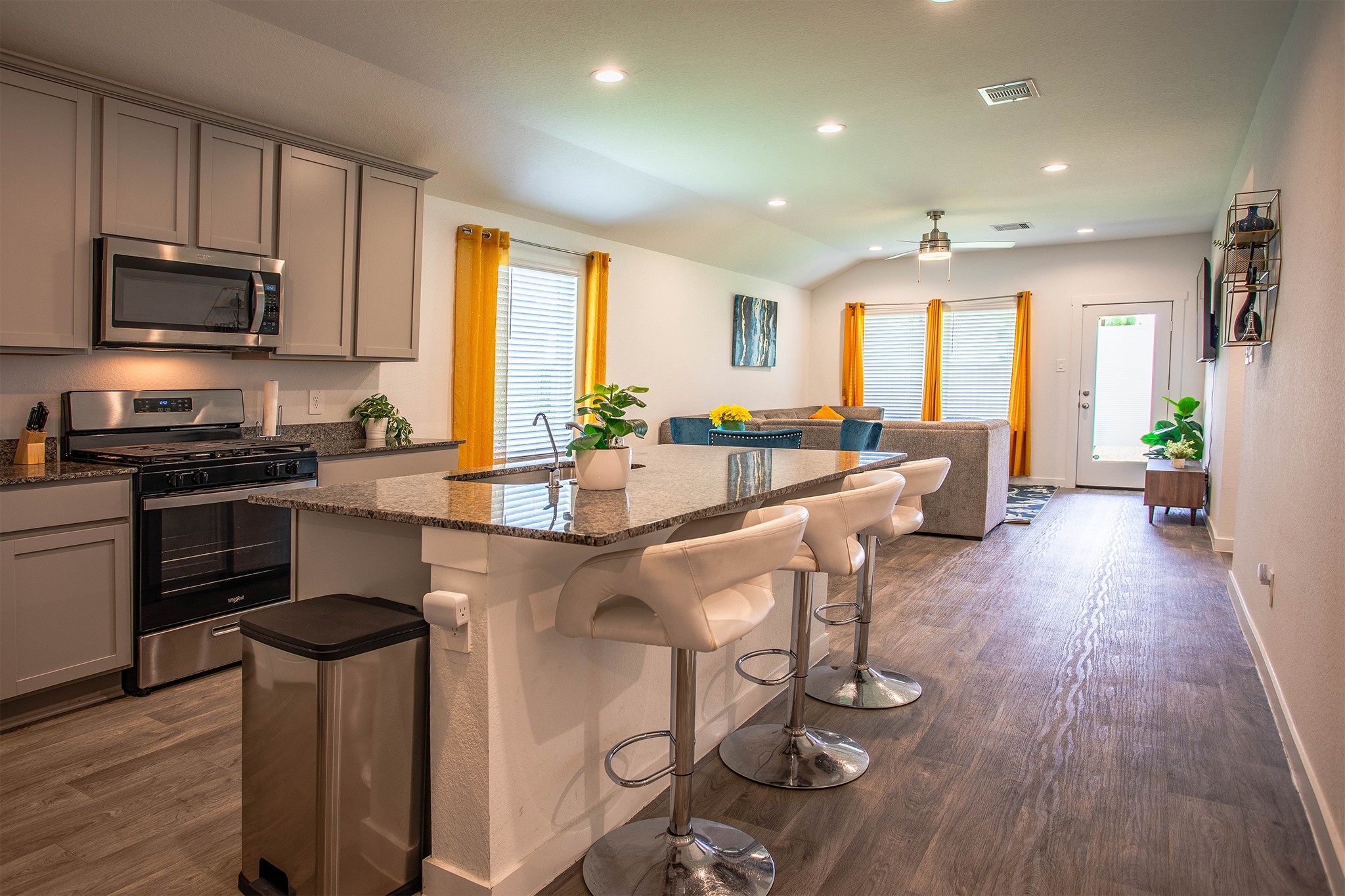 31810 Whittis Hill Way Fulshear, TX 77441 - Photo 3 of 23 Step inside to an open-concept layout that blends style and functionality. This bright, airy kitchen features granite countertops, sleek stainless steel appliances, and a spacious island with bar seating—perfect for entertaining or casual meals.