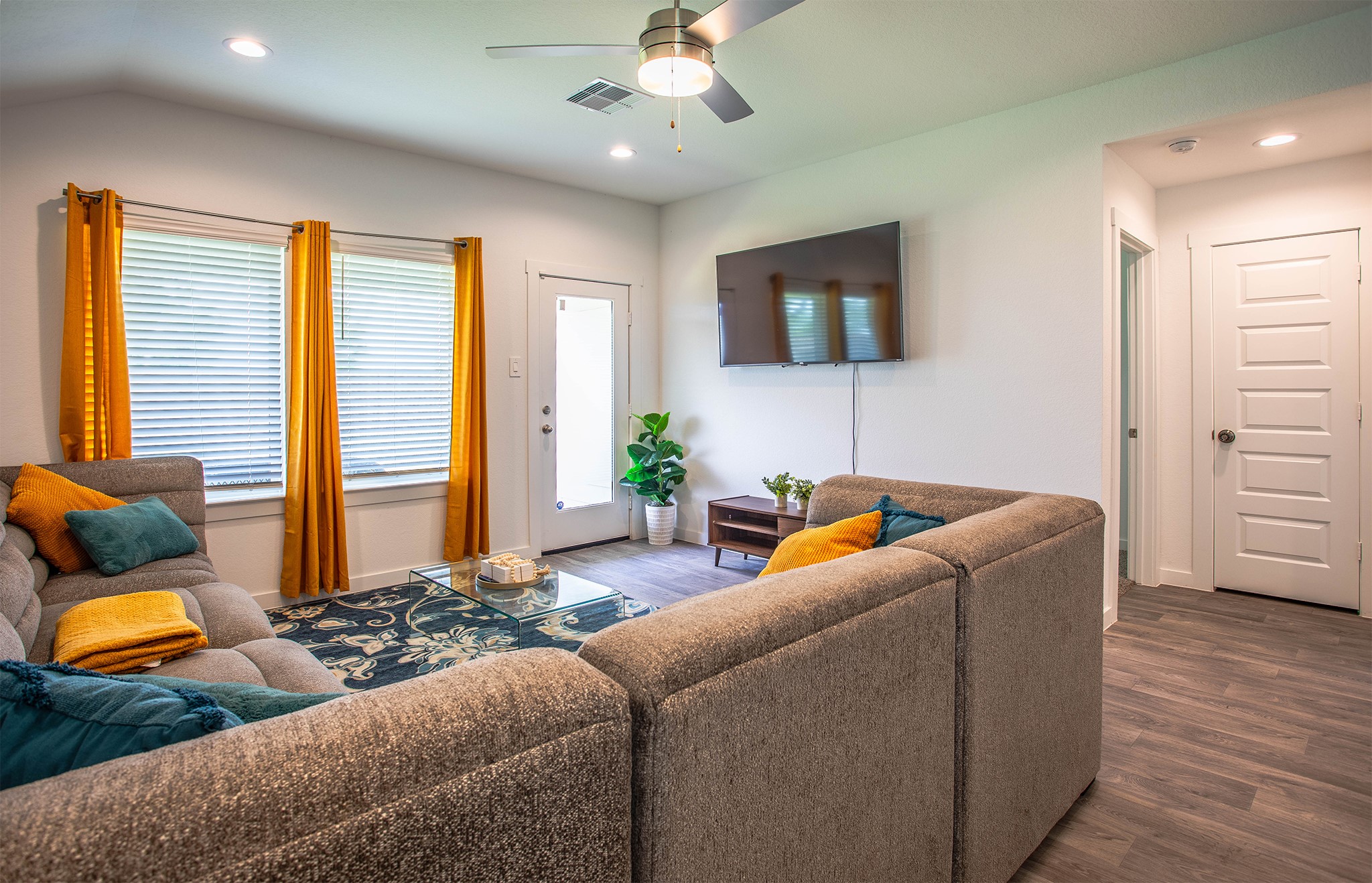 31810 Whittis Hill Way Fulshear, TX 77441 - Photo 7 of 23 This bright and welcoming living room features a large sectional, vibrant gold curtains, and modern finishes—perfect for relaxing or entertaining in style. Notice all the space.