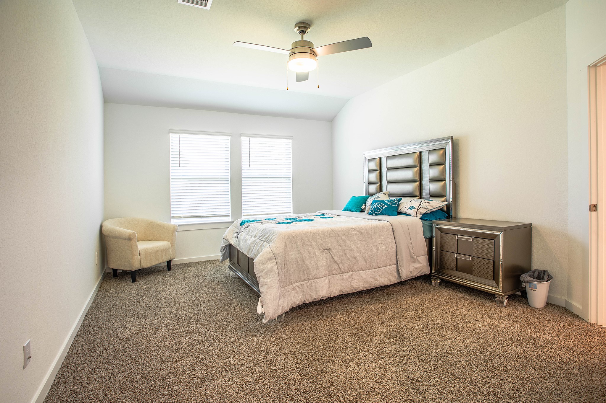 31810 Whittis Hill Way Fulshear, TX 77441 - Photo 9 of 23 The primary bedroom features a spacious layout with plush carpeting, abundant natural light, and modern furniture that adds a touch of luxury and comfort.
