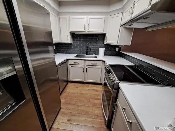 a kitchen with a sink a stove and cabinets