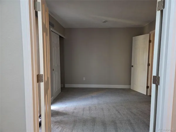 an empty room with windows and closet