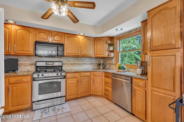 a kitchen with stainless steel appliances granite countertop a stove a sink and a microwave