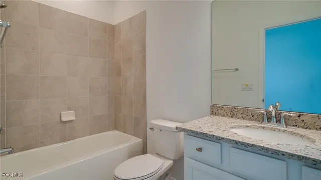 a bathroom with a granite countertop toilet sink and bathtub