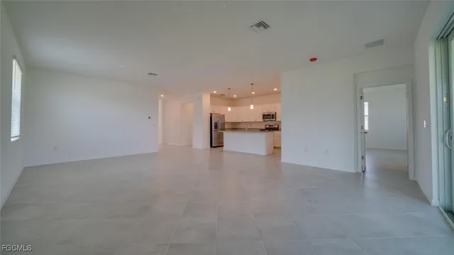 a view of a big room with kitchen and chandelier