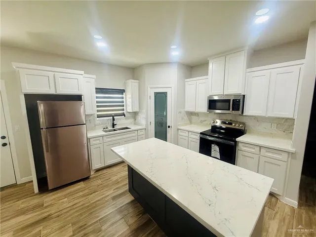 a kitchen with white cabinets and stainless steel appliances