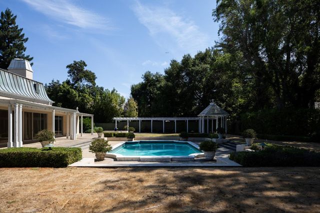 a view of a house with backyard and sitting area