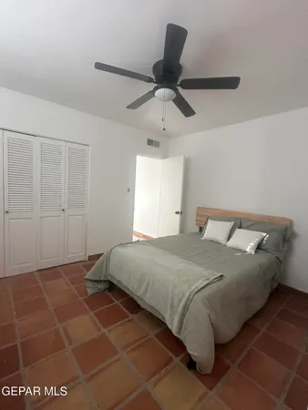 a bedroom with a bed and a ceiling fan