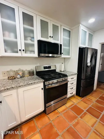a kitchen with stainless steel appliances granite countertop a stove a refrigerator and a sink