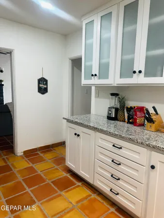 a kitchen with granite countertop a sink and cabinets