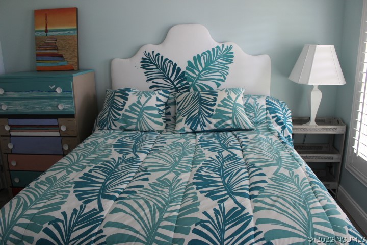 827 11th Avenue New Smyrna Beach, FL 32169 - Photo 12 of 21 a bedroom with a bed and a lamp