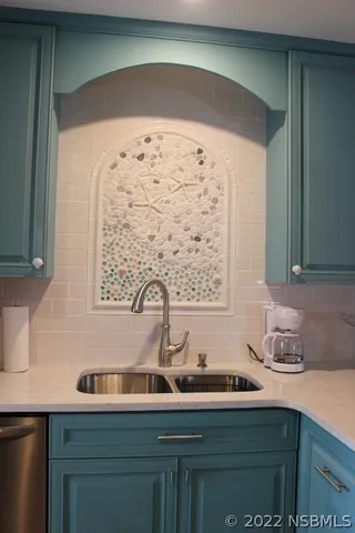 a living room with furniture a flat screen tv and kitchen view