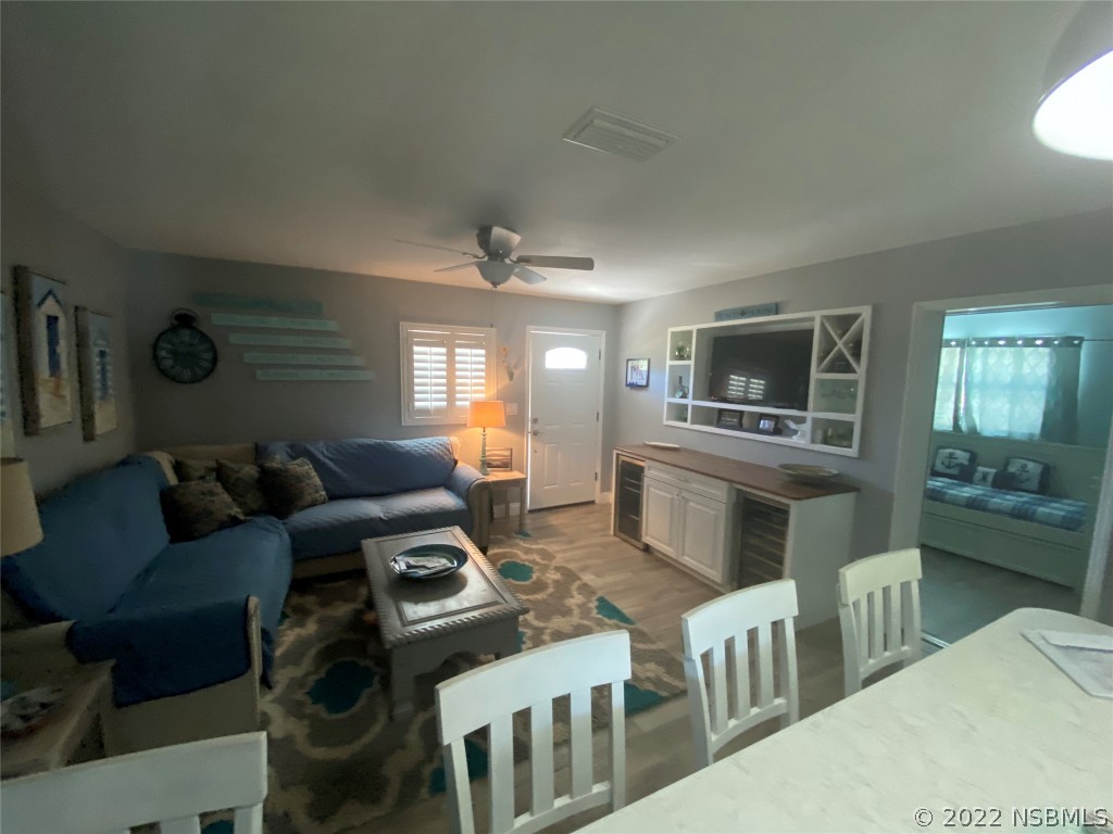 827 11th Avenue New Smyrna Beach, FL 32169 - Photo 4 of 21 a living room with furniture a flat screen tv and kitchen view