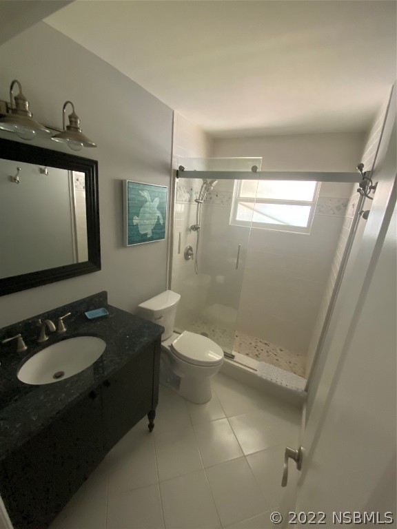 827 11th Avenue New Smyrna Beach, FL 32169 - Photo 5 of 21 a bathroom with a granite countertop sink toilet a mirror and shower