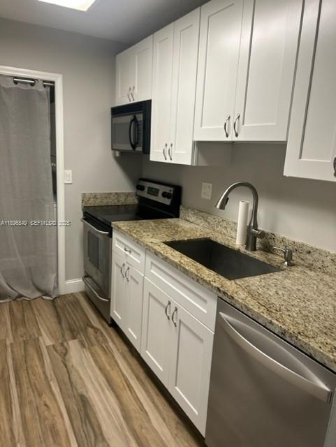 a kitchen with granite countertop a sink stainless steel appliances and cabinets