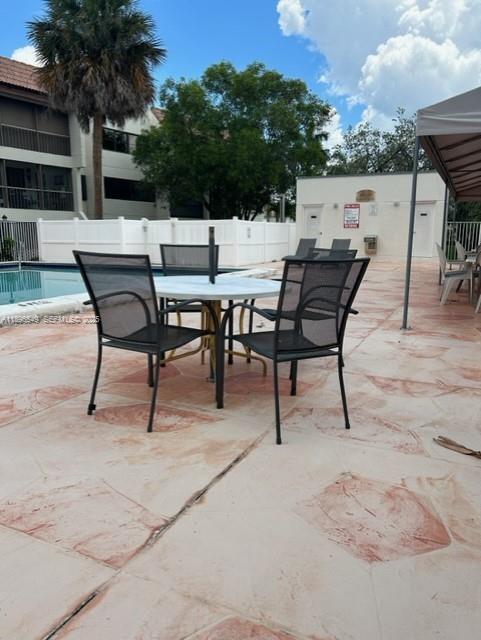 303 Racquet Club Road, Unit 106 Weston, FL 33326 - Photo 15 of 23 a view of a patio with a table and chairs