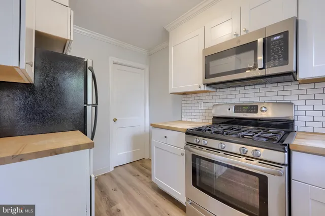a kitchen with stainless steel appliances wooden cabinets and a stove top oven