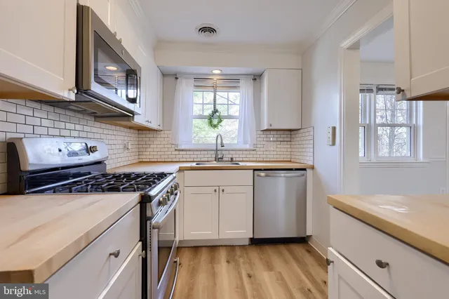 a kitchen that has a sink a stove and window