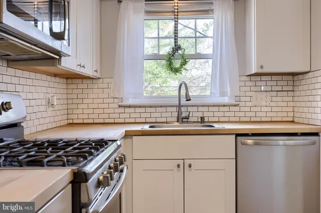a kitchen with granite countertop a sink stove and cabinets