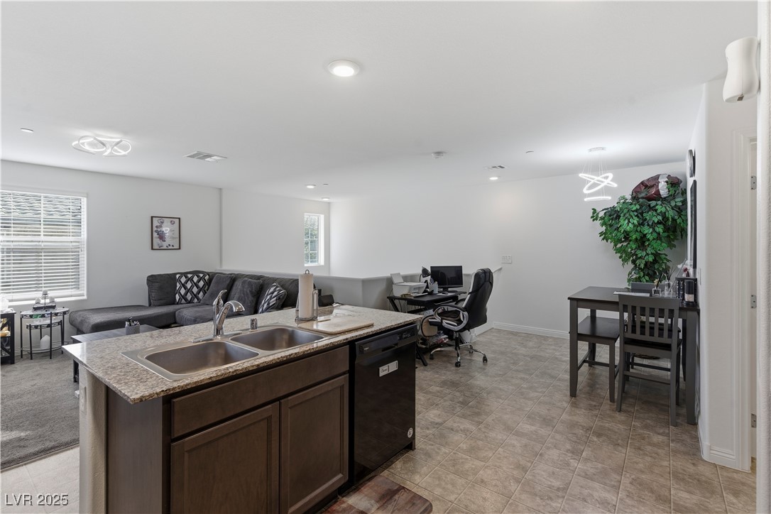 4648 Woolcomber Street Las Vegas, NV 89115 - Photo 41 of 41 Kitchen with dark brown cabinetry, a desk, open floor plan, a kitchen island with sink, and black dishwasher