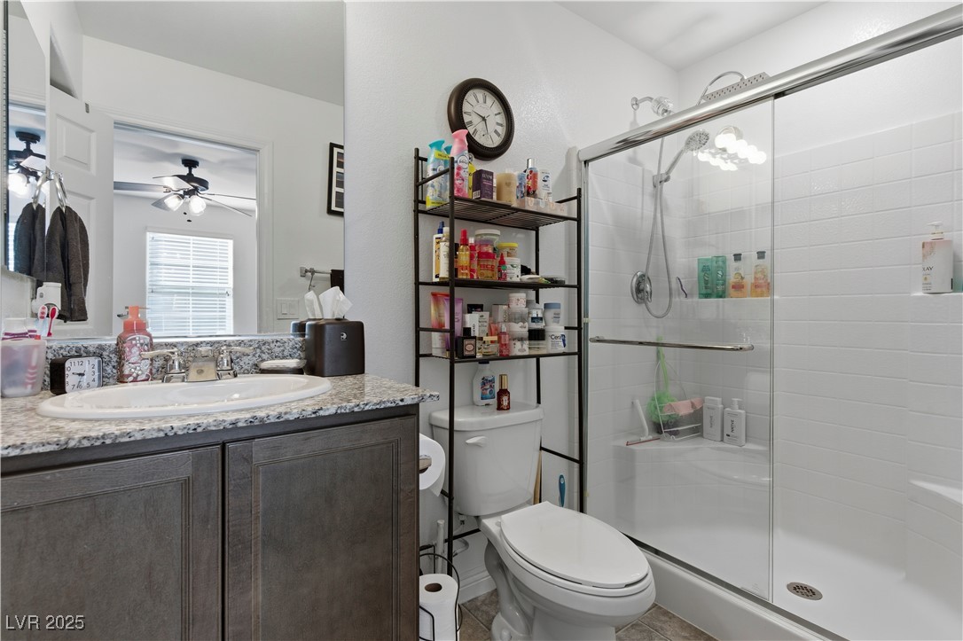 4648 Woolcomber Street Las Vegas, NV 89115 - Photo 22 of 41 Bathroom with vanity, a shower stall, a ceiling fan, and light tile patterned floors