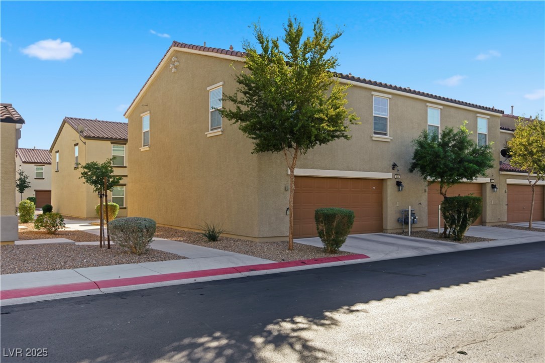 4648 Woolcomber Street Las Vegas, NV 89115 - Photo 30 of 41 View of front facade with stucco siding, driveway, and a garage