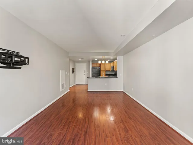 a view of empty room with wooden floor