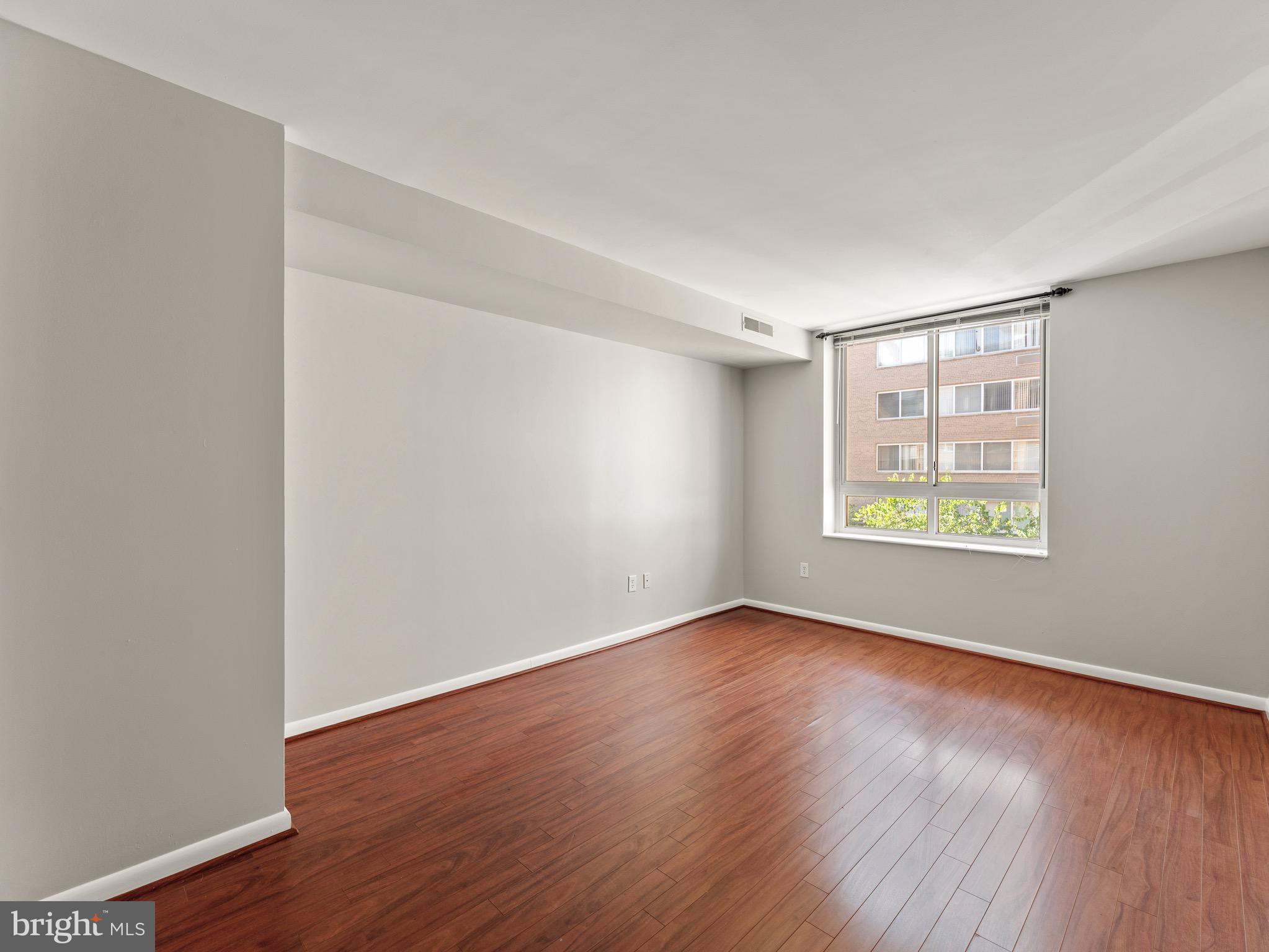 350 G Street Southwest, Unit N310 Washington, DC 20024 - Photo 13 of 26 a view of an empty room with wooden floor and a window
