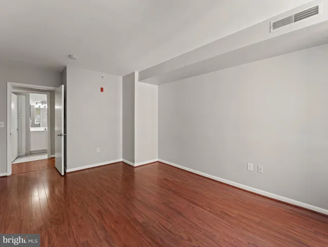 a view of an empty room with wooden floor
