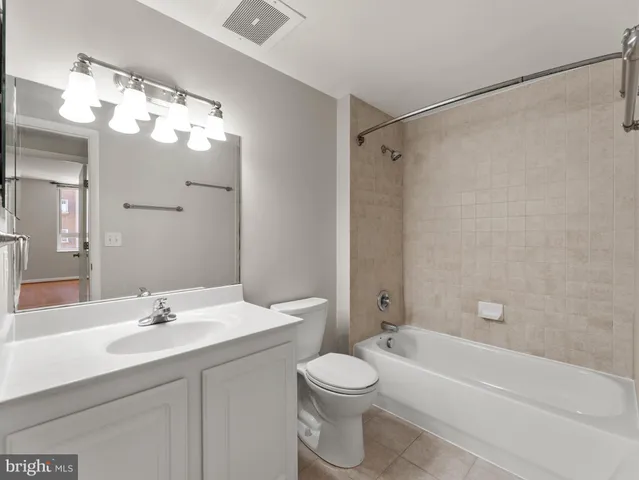 a bathroom with a sink a toilet and a large mirror