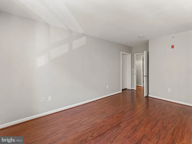 a view of an empty room with wooden floor