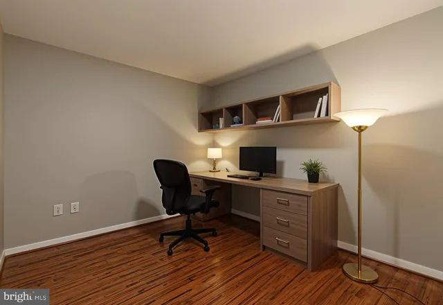 a view of a workspace with furniture and a window