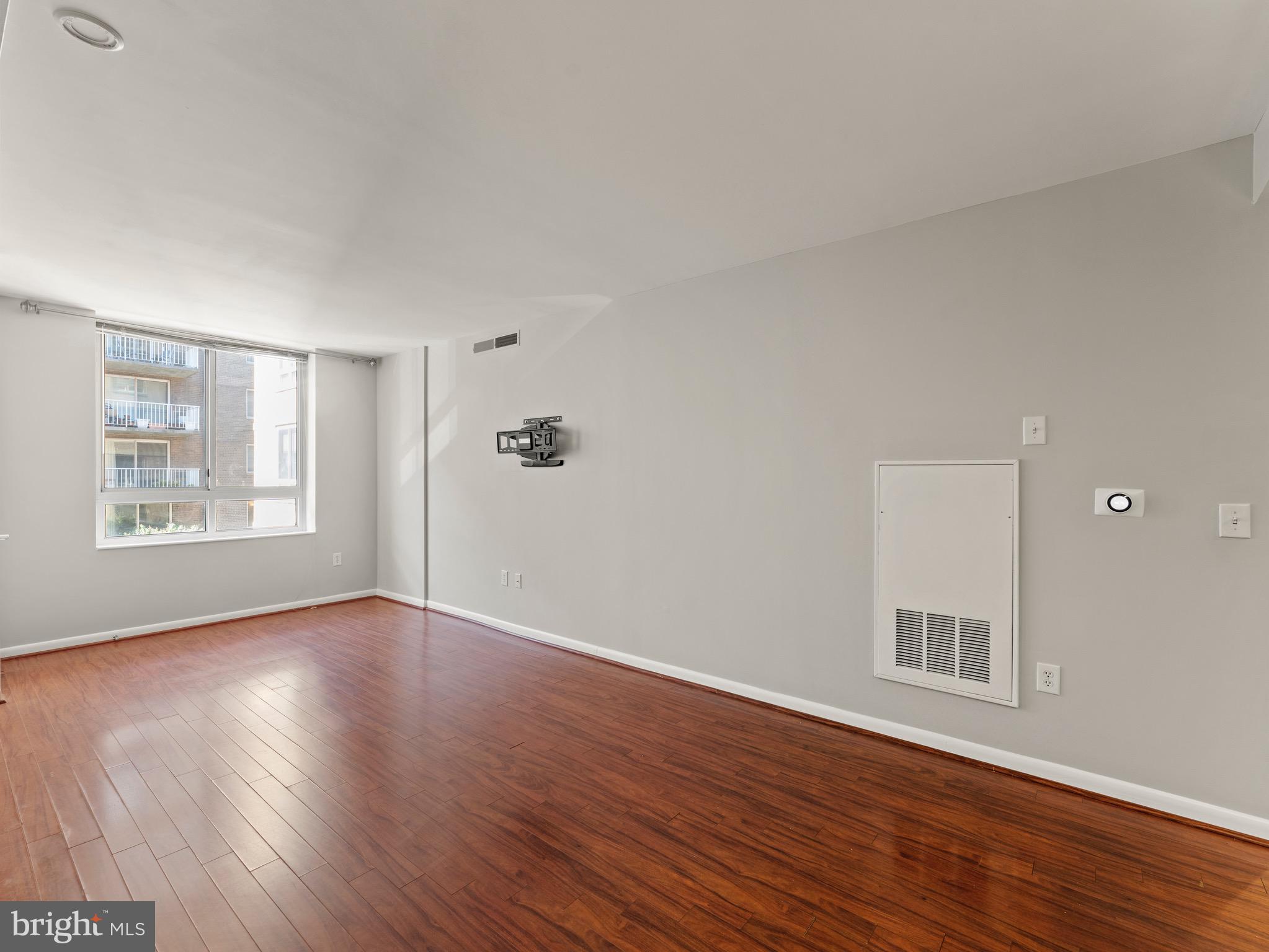 350 G Street Southwest, Unit N310 Washington, DC 20024 - Photo 9 of 26 a view of an empty room with wooden floor and a window