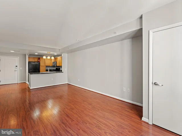 a view of a big room with wooden floor and a kitchen