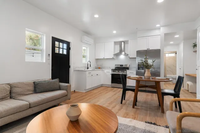 a living room with furniture and a dining table with kitchen view