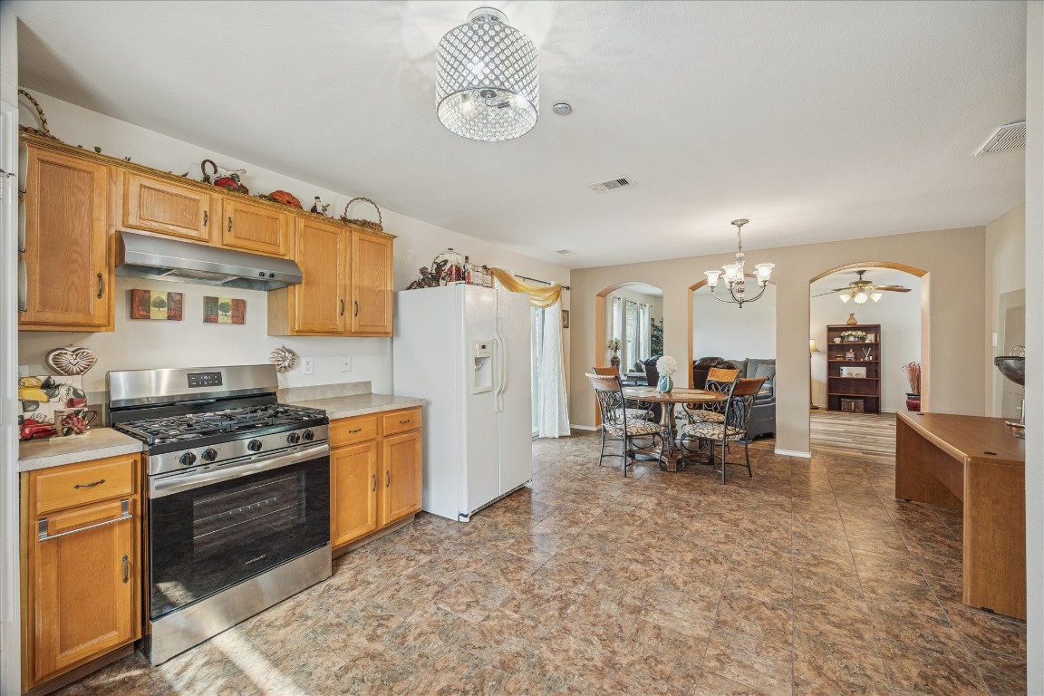 12811 Rio Lindo Street Rosharon, TX 77583 - Photo 2 of 13 a kitchen with stainless steel appliances a stove a sink and a refrigerator