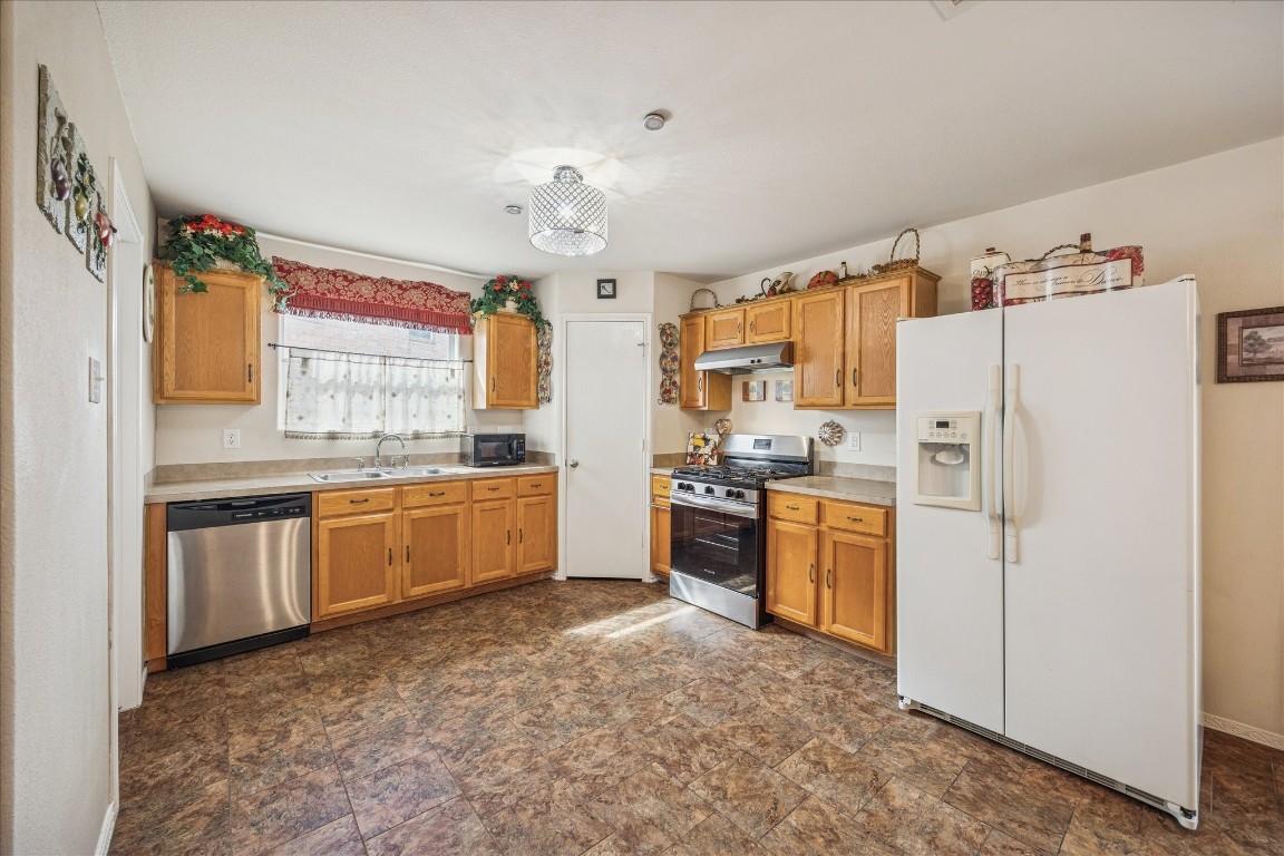 12811 Rio Lindo Street Rosharon, TX 77583 - Photo 3 of 13 a kitchen with granite countertop a refrigerator stove top oven and sink