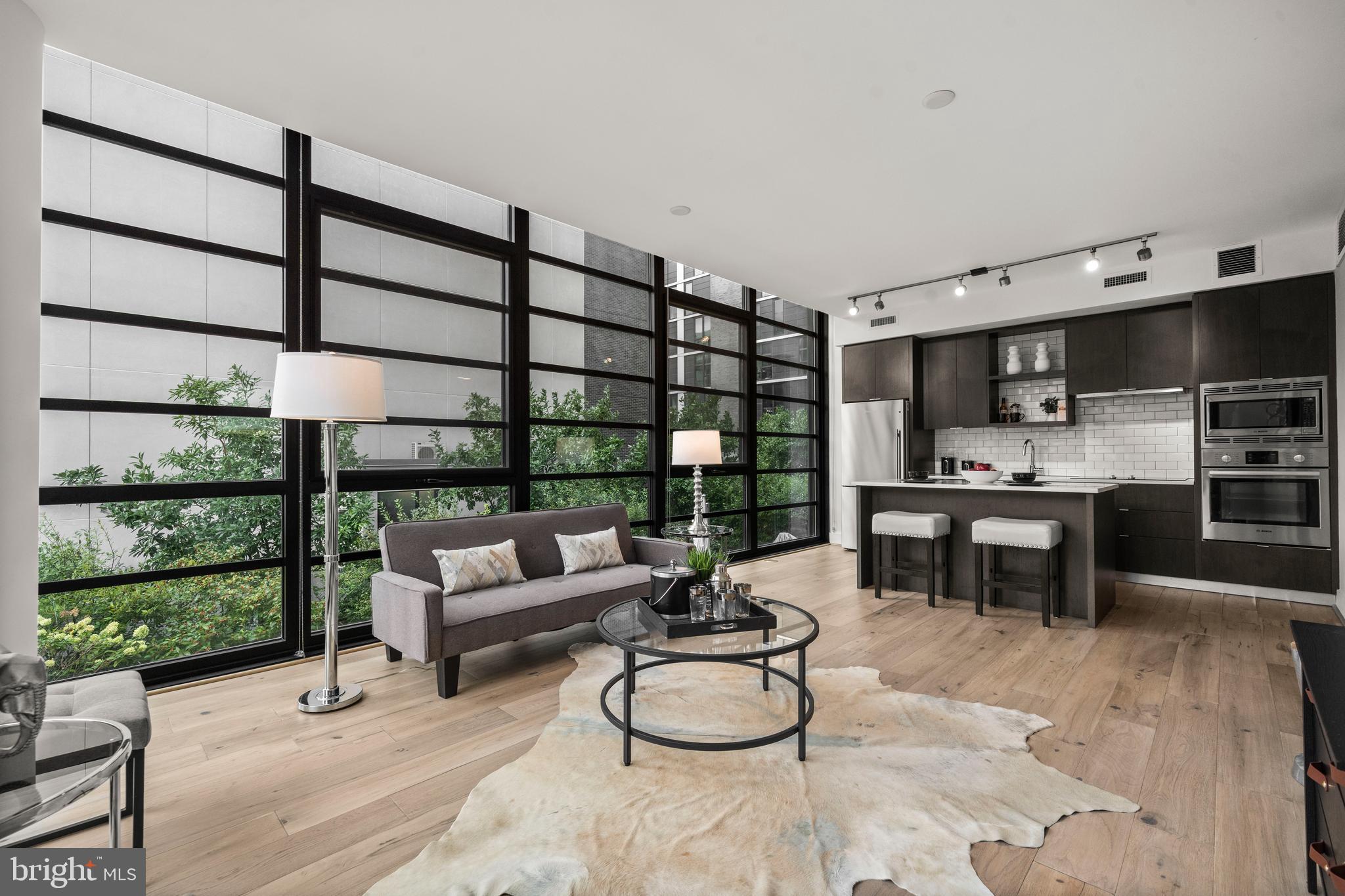 a living room with furniture a rug and kitchen view
